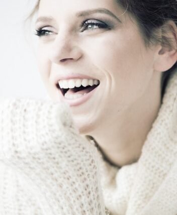 Mujer con sonrisa perfecta tras tratamiento de estética dental en Lumana Odontología